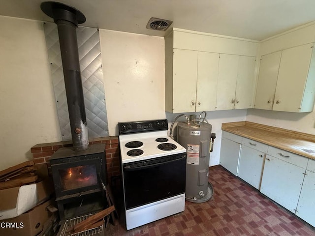 kitchen featuring visible vents, a wood stove, light countertops, water heater, and electric range