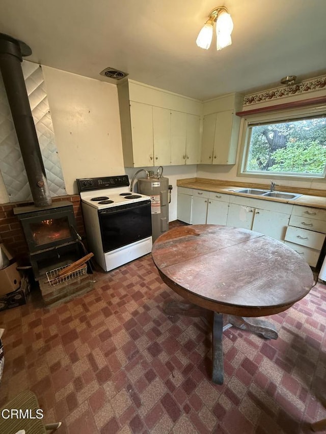 kitchen with brick floor, visible vents, a sink, and white electric stove