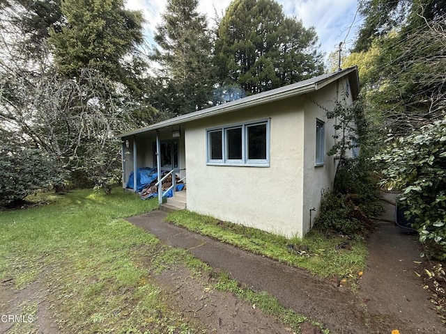 back of house featuring a yard and stucco siding