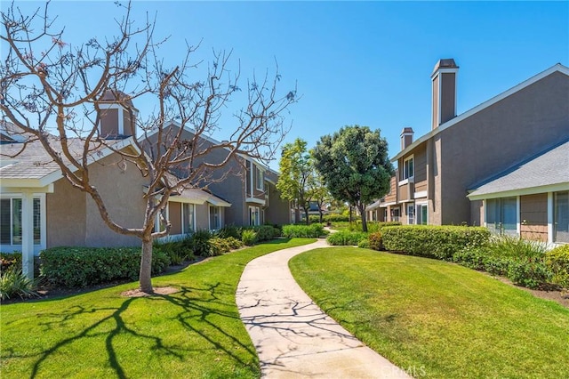 view of property's community with a residential view and a lawn