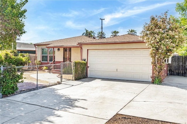 ranch-style house with an attached garage, driveway, stucco siding, and a fenced front yard