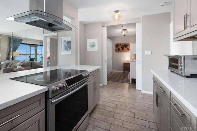 4007 Everts St Unit 4H, Pacific Beach San Diego, CA 92109 - kitchen featuring stainless steel electric range, island range hood, gray cabinets, and light wood-style flooring