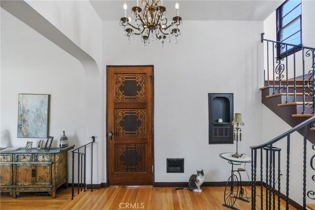4368 Adams Ave, San Diego, CA 92116 - entryway with a chandelier, wood finished floors, stairway, and arched walkways