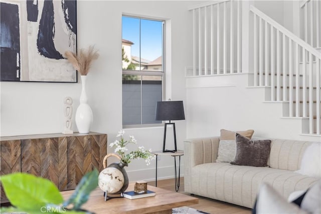 living room featuring stairway, baseboards, and wood finished floors