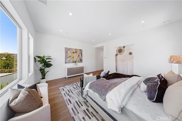 bedroom with recessed lighting, radiator heating unit, visible vents, and wood finished floors