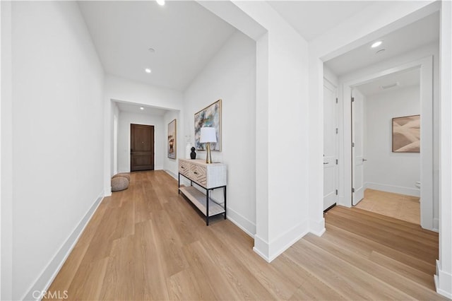 hall with light wood-type flooring, baseboards, and recessed lighting