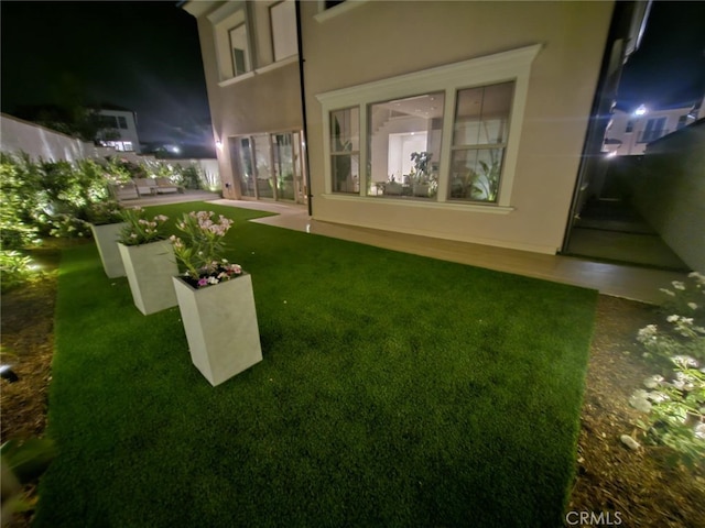 yard at night featuring a patio