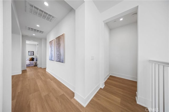 hallway with visible vents, wood finished floors, and recessed lighting