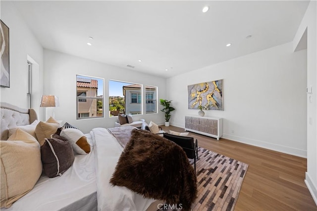 bedroom featuring recessed lighting, wood finished floors, visible vents, and baseboards