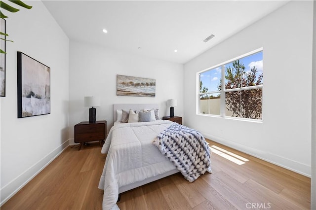 bedroom featuring visible vents, baseboards, wood finished floors, and recessed lighting