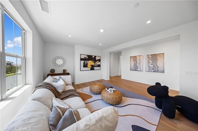 living room with recessed lighting, wood finished floors, visible vents, and baseboards