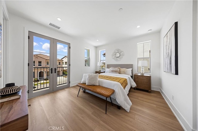 bedroom featuring light wood finished floors, french doors, access to exterior, and visible vents