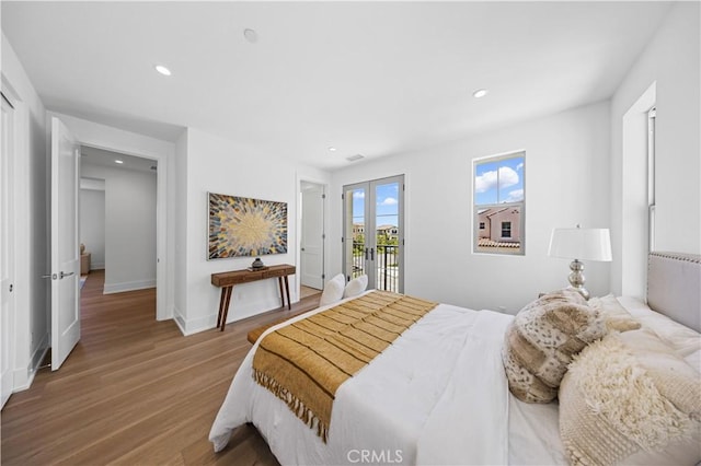 bedroom with french doors, wood finished floors, access to exterior, and recessed lighting