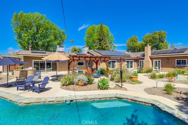 6217 Melba Ave, Woodland Hills, CA 91367 - rear view of house with stucco siding, solar panels, a patio area, an outdoor pool, and a pergola