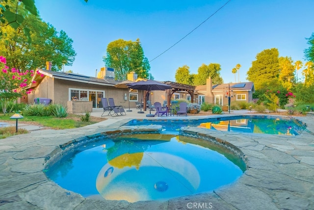 view of pool with a patio area and a pool with connected hot tub