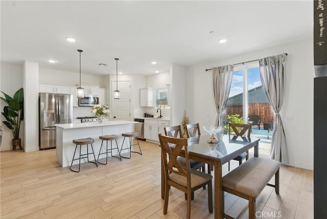 dining room featuring light wood finished floors and recessed lighting