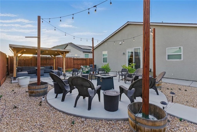view of patio featuring a fenced backyard and an outdoor living space with a fire pit