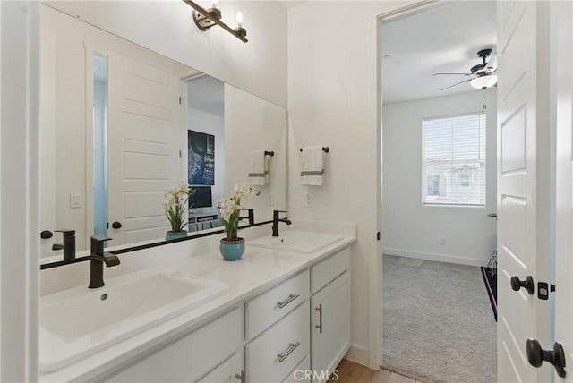 bathroom featuring double vanity, baseboards, a sink, and ceiling fan