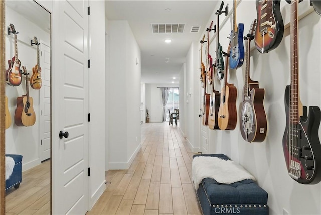 hallway featuring visible vents, light wood-style flooring, recessed lighting, and baseboards