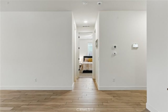spare room with light wood-style floors, baseboards, and visible vents