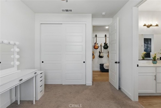 interior space featuring a closet, light colored carpet, and visible vents