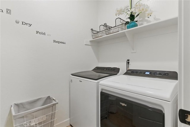 clothes washing area with independent washer and dryer, laundry area, and baseboards