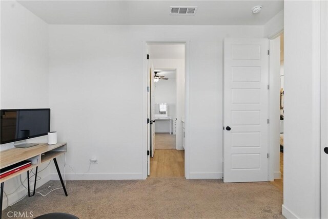 home office with carpet flooring, visible vents, baseboards, and a ceiling fan
