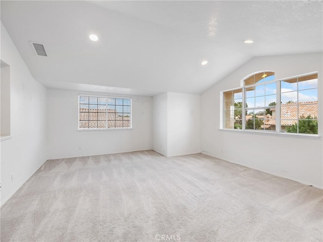 carpeted spare room with recessed lighting, vaulted ceiling, and visible vents