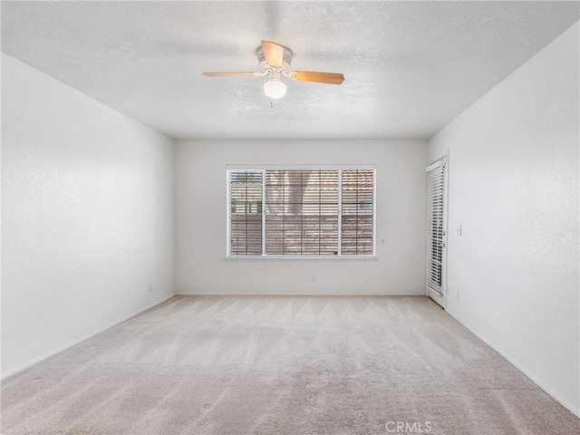 spare room featuring ceiling fan and light colored carpet