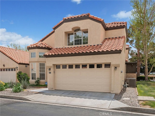 mediterranean / spanish home with cooling unit, a tiled roof, and stucco siding