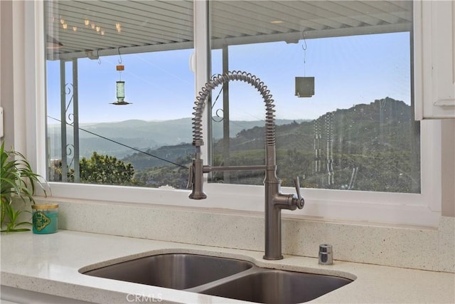 31725 Rancho Amigos Rd, Bonsall, CA 92003 - interior details with light stone counters, a sink, a mountain view, and white cabinets
