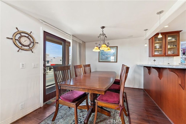 2408 Ocean Dr, Oxnard, CA 93035 - dining area with dark wood-style floors, baseboards, and an inviting chandelier
