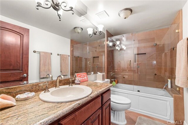 2408 Ocean Dr, Oxnard, CA 93035 - full bathroom featuring visible vents, bath / shower combo with glass door, toilet, vanity, and tile patterned flooring