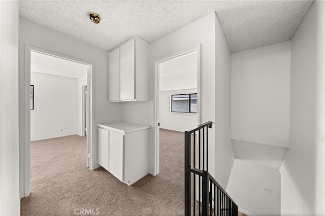 1144 N Lyman Ave, Covina, CA 91724 - hallway featuring light carpet, an upstairs landing, and a textured ceiling