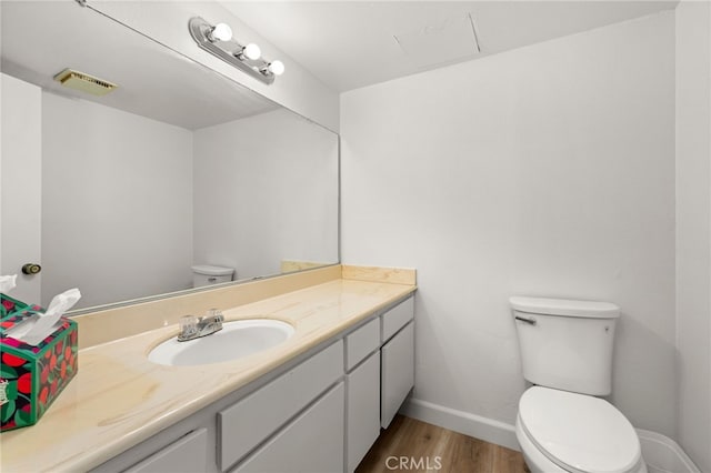 1144 N Lyman Ave, Covina, CA 91724 - half bath featuring vanity, visible vents, toilet, wood finished floors, and baseboards