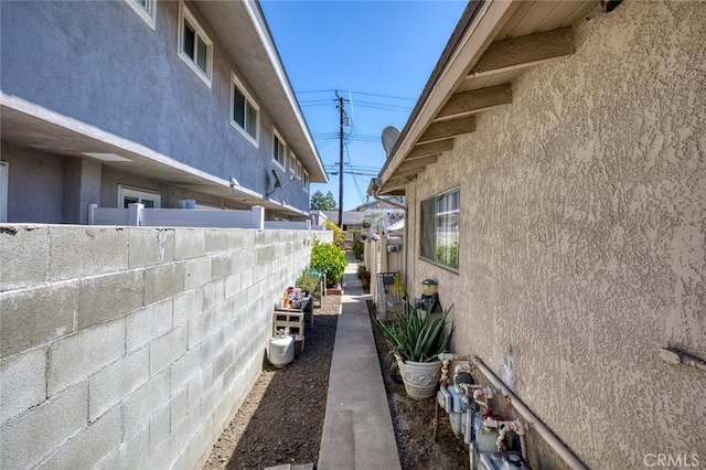 view of property exterior featuring stucco siding and fence