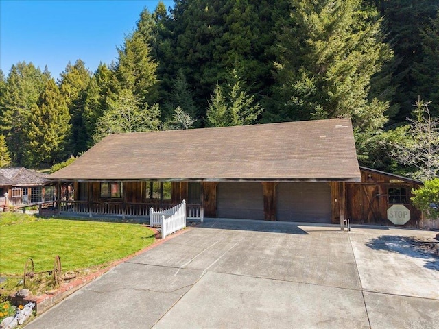view of front of property featuring a porch, a forest view, and a front lawn
