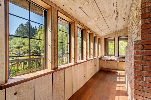 unfurnished sunroom with wood ceiling, vaulted ceiling, and hardwood / wood-style flooring