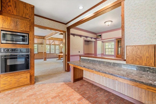 kitchen featuring crown molding, stainless steel microwave, brick floor, wallpapered walls, and oven