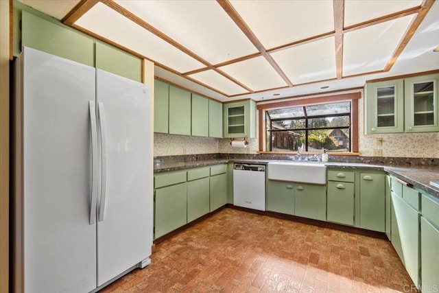 kitchen with glass insert cabinets, white appliances, brick patterned floor, dark countertops, and green cabinetry