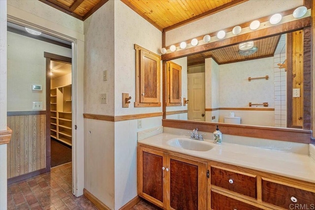 bathroom with a walk in closet, vanity, brick floor, and wood ceiling