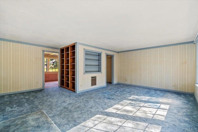 carpeted empty room featuring baseboards and ornamental molding