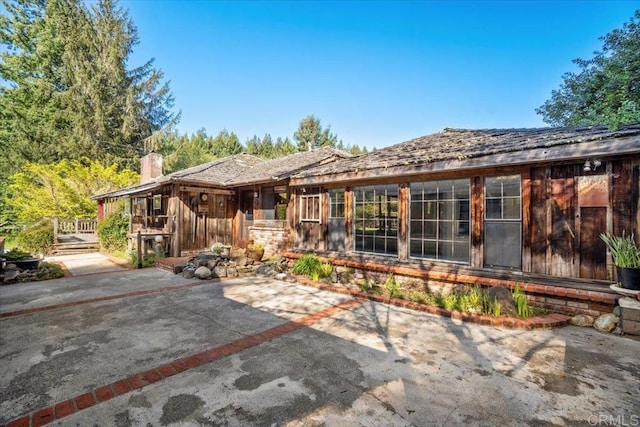 rear view of house featuring a patio area and a chimney