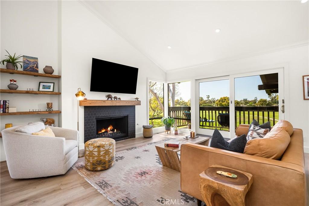 25 Rana, Irvine, CA 92612 - living area featuring high vaulted ceiling, a lit fireplace, wood finished floors, and recessed lighting