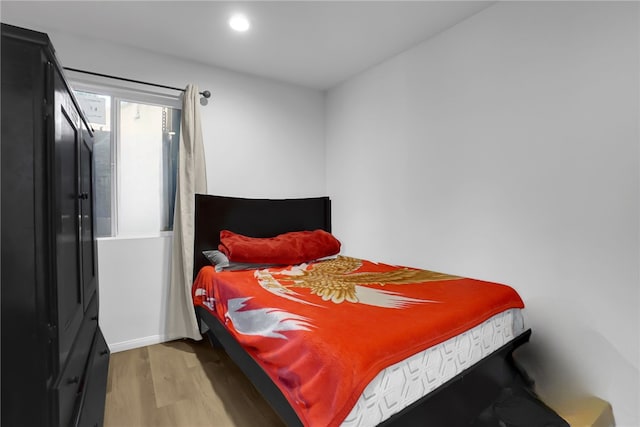 bedroom with recessed lighting and wood finished floors