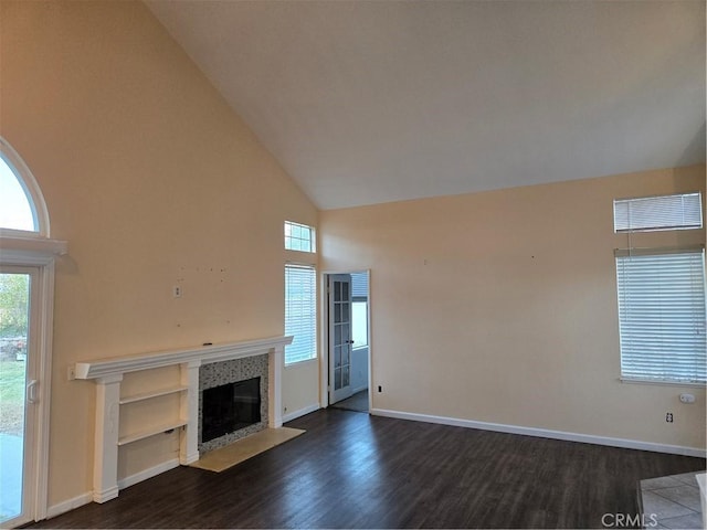 unfurnished living room featuring high vaulted ceiling, a fireplace with flush hearth, baseboards, dark wood-style flooring, and visible vents