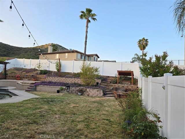 view of yard featuring a fenced backyard and a mountain view