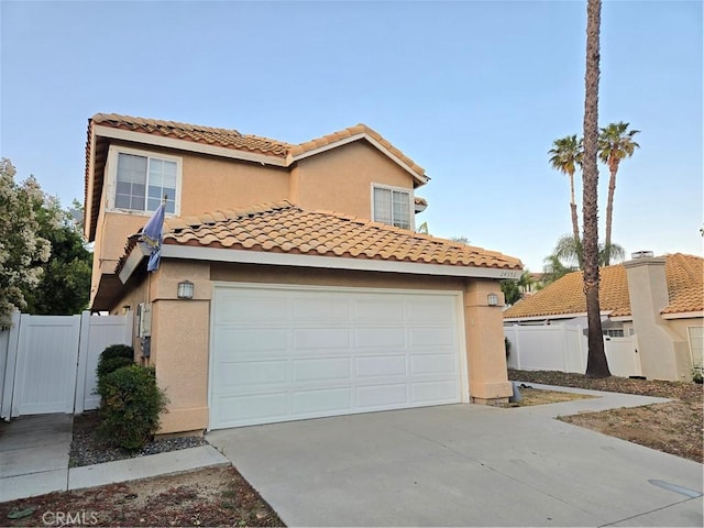 view of front of home featuring a garage, concrete driveway, and fence
