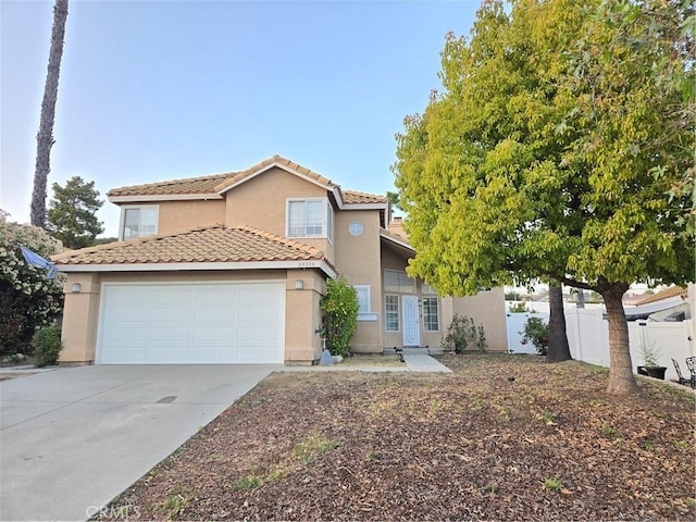 traditional home with concrete driveway, a tiled roof, fence, a garage, and stucco siding