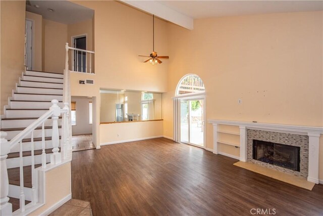 24356 Via Las Junitas, Murrieta, CA 92562 - unfurnished living room with ceiling fan, a tiled fireplace, wood finished floors, stairway, and beamed ceiling